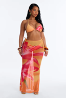 Woman modeling a vibrant orange and pink floral bikini and matching sheer maxi skirt cover-up.