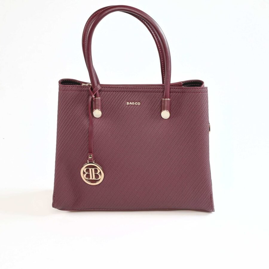 Sac à main en cuir bordeaux avec logo et porte-clés or, élégant et pratique..