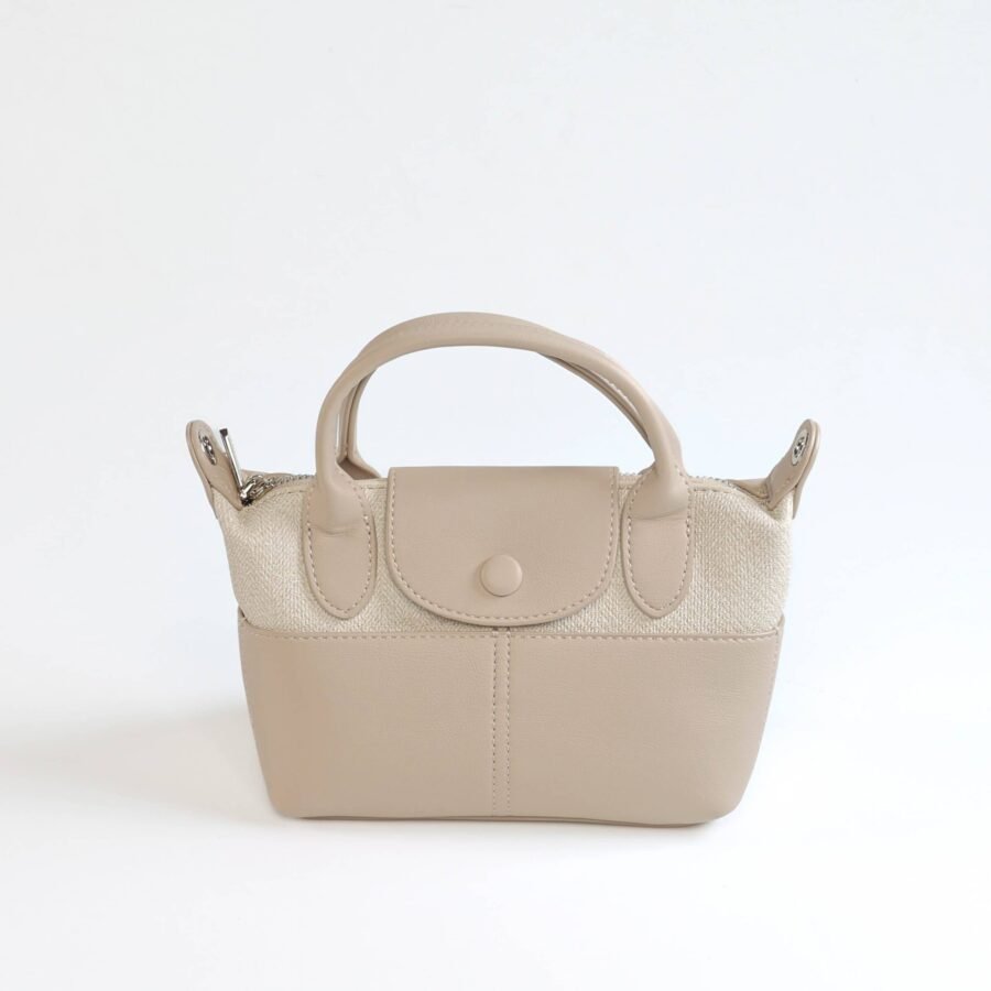 Sac à main beige en cuir synthétique avec poignée robuste et fermeture sécurisée..